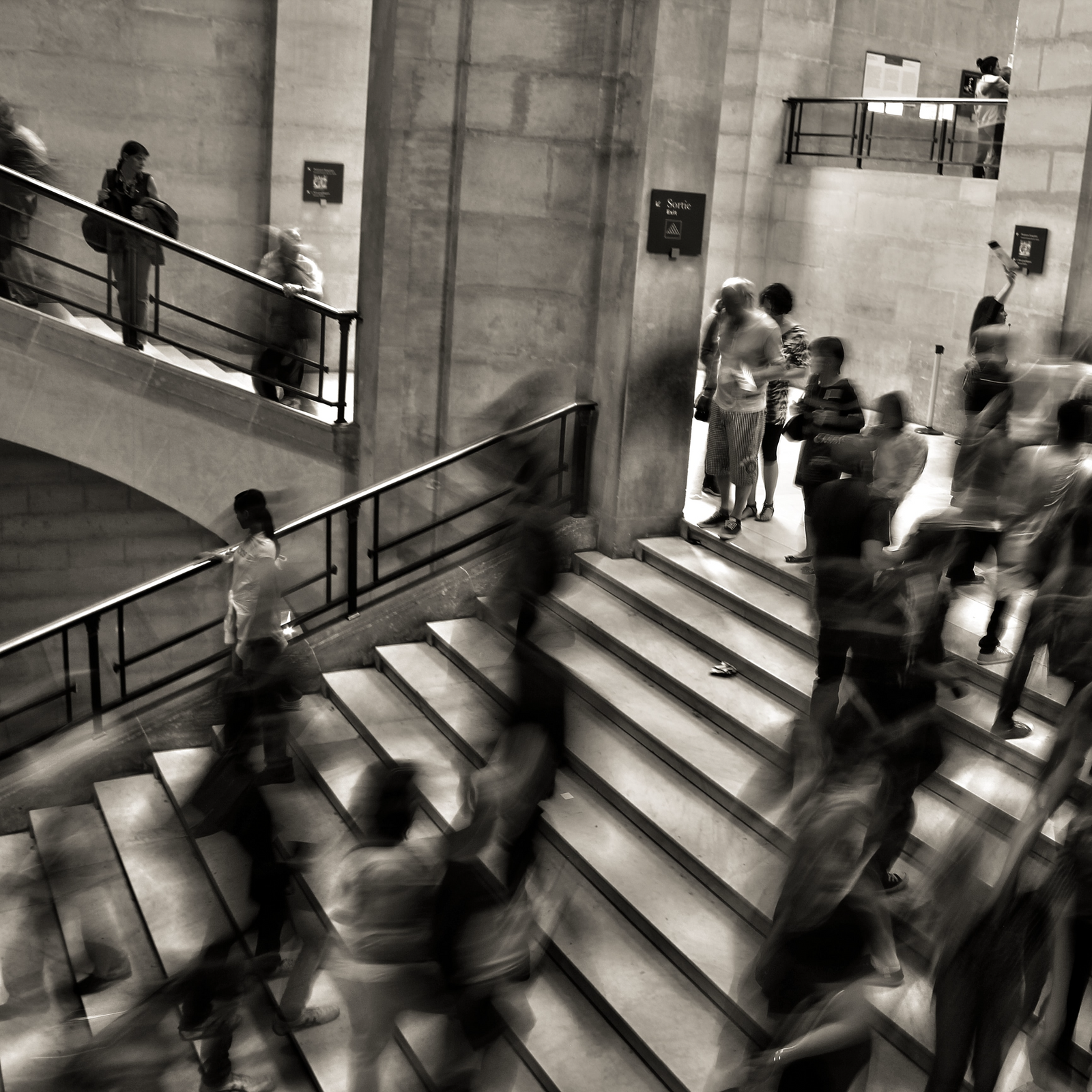many people walking around staircase